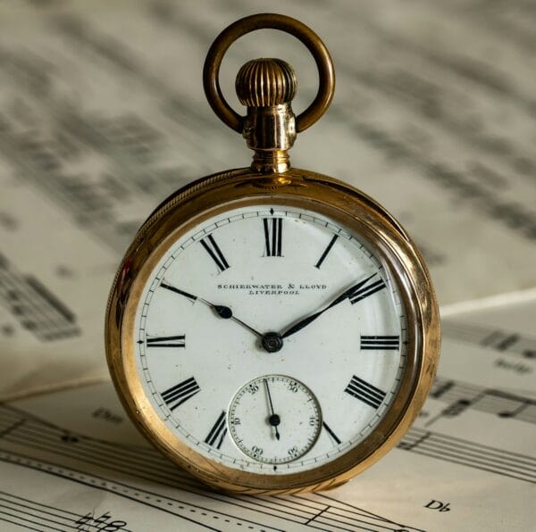 a pocket watch sitting on top of sheet music